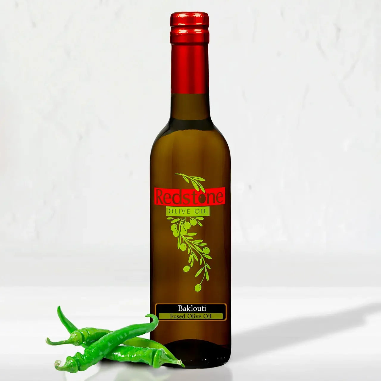 Baklouti Green Chili fused extra virgin olive oil in a dark amber bottle with red cap, with fresh green chili peppers, by Redstone Olive Oil