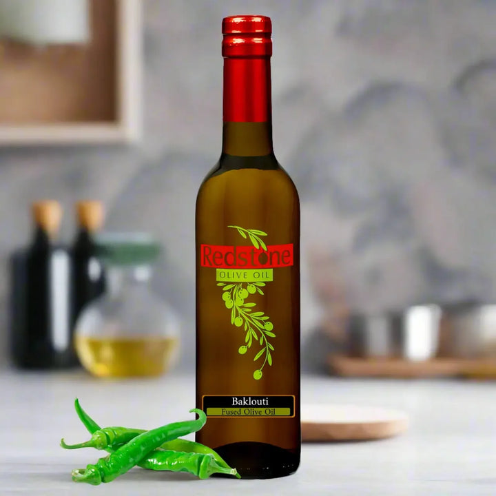Baklouti Green Chili fused extra virgin olive oil by Redstone Olive Oil, styled with fresh green chili peppers in a warm kitchen setting
