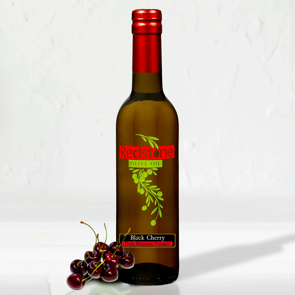 Close-up of Black Cherry Balsamic Vinegar bottle black cherry fruit in the background