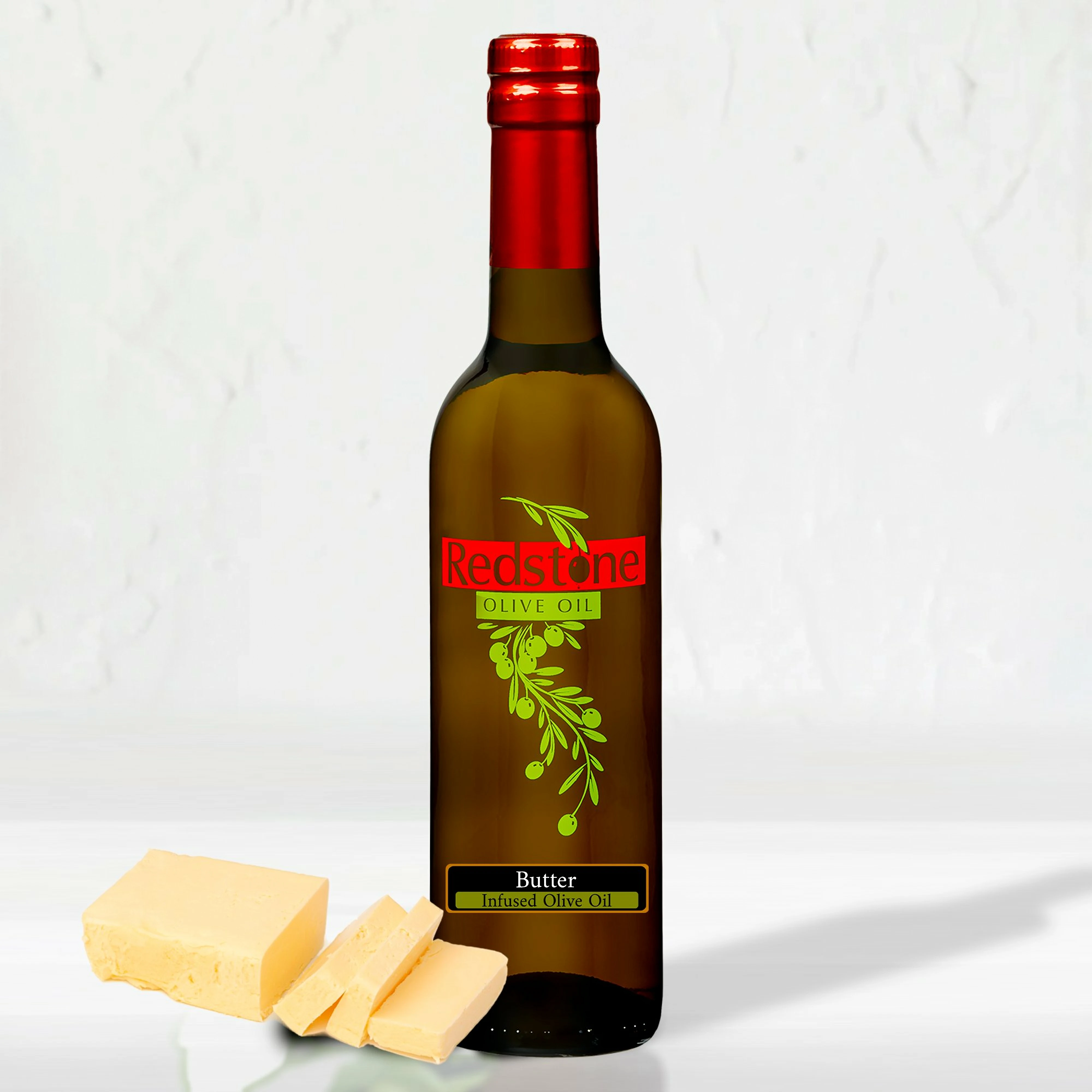 A single bottle of butter-infused olive oil next to a wedge of artisan cheese