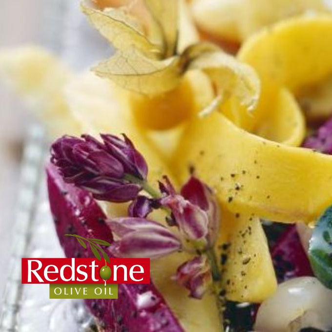Fruit skewer with yellow pineapple, purple dragon fruit, and green kiwi on a clear plate.