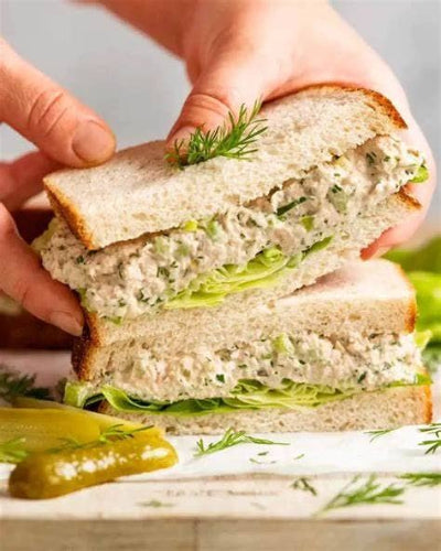 Fresh sandwich with dill mustard, lettuce, and creamy filling, served with pickles