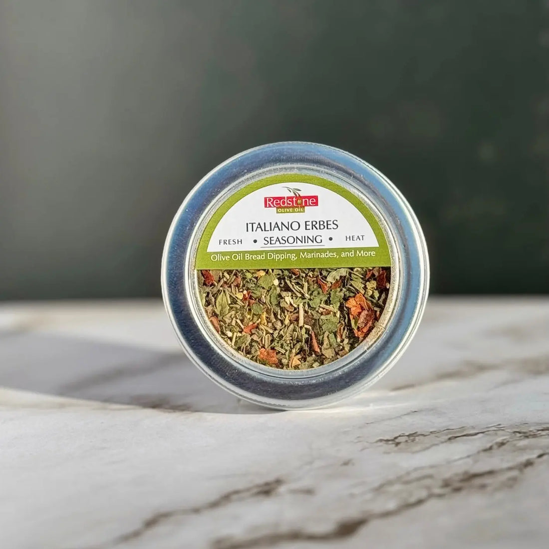 Tin of Italiano Erbes seasoning blend for olive oil bread dipping on marble surface