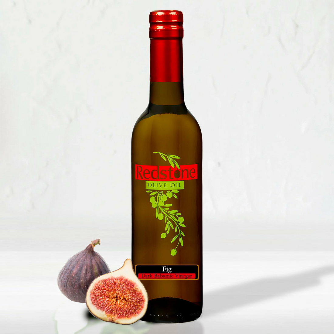 A single bottle of Fig Balsamic Vinegar with fresh figs arranged beside it