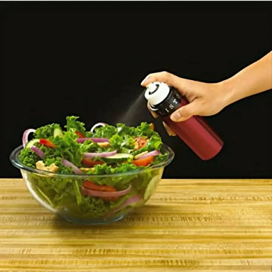 Misting Redstone olive oil onto a fresh salad using the Misto stainless steel pump sprayer