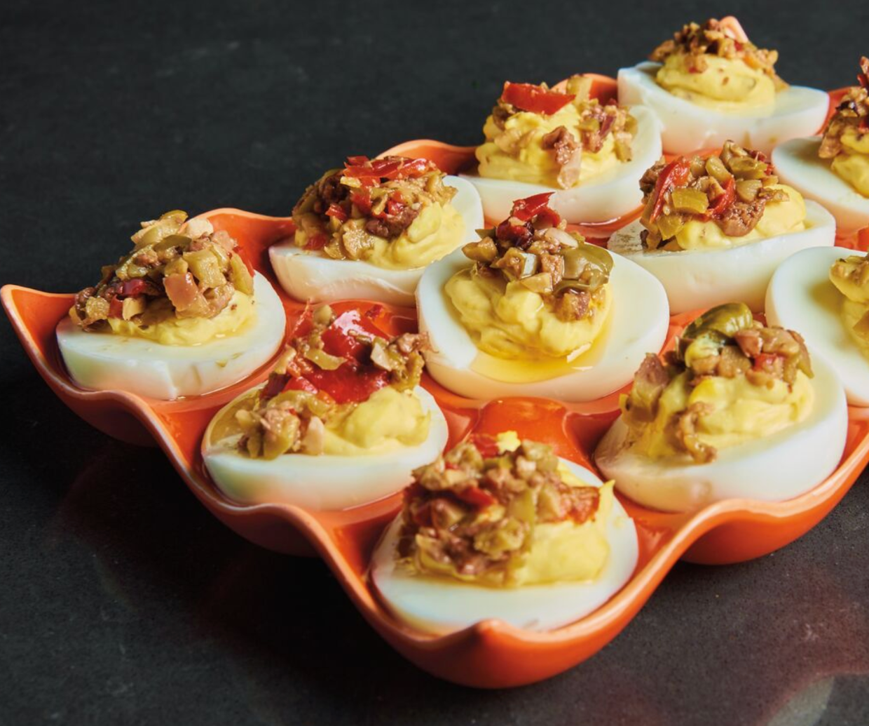 olive bruschetta on develed eggs on tray