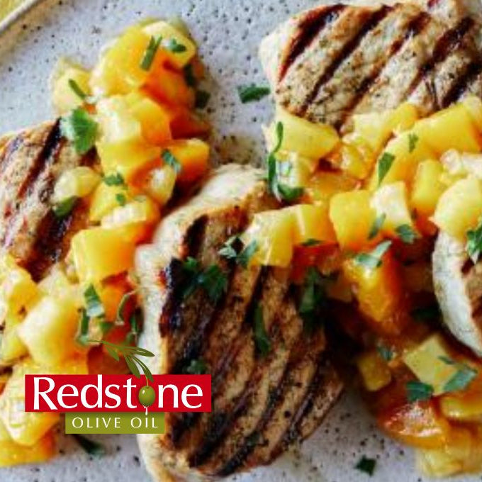 Grilled chicken with mango salsa on a speckled plate, featuring Redstone Olive Oil branding.