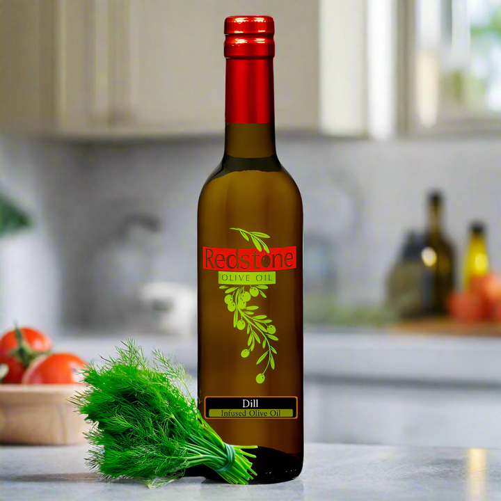bottle of Redstone Olive Oil dill flavor on a kitchen counter with fresh tomatoes and dill