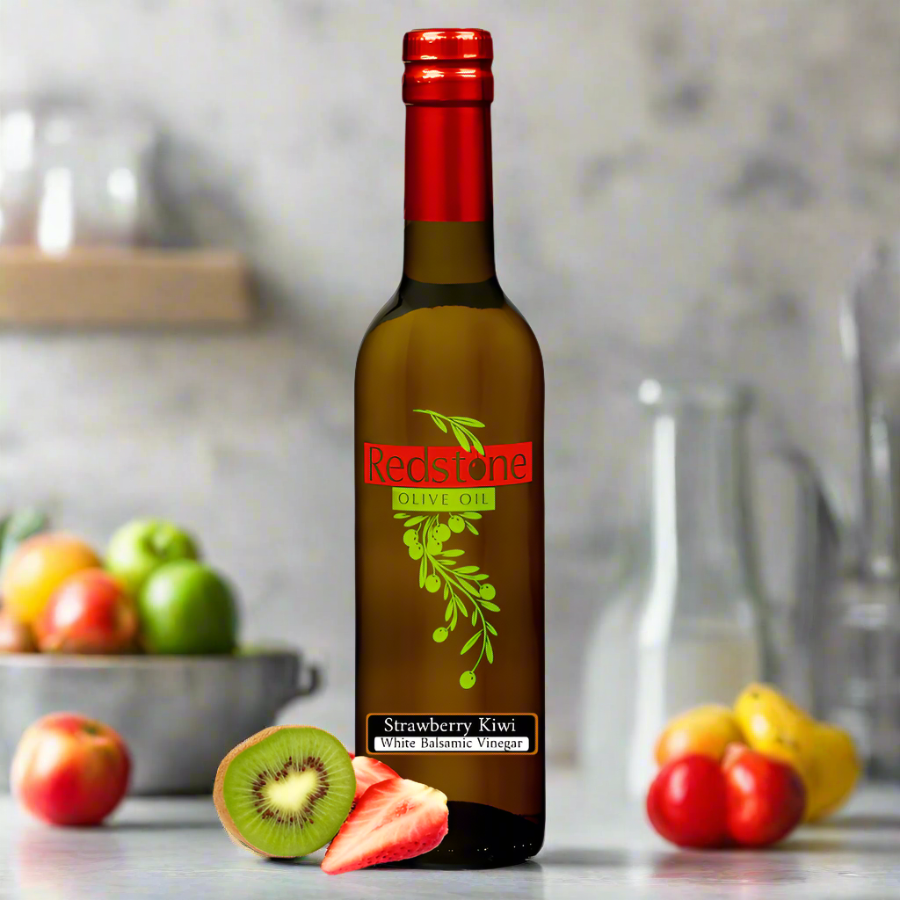 a bottle of strawberry kiwi balsamic on the kitchen counter with fresh fruit