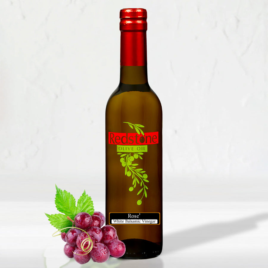 a bottle of Rose White Balsamic Vinegar on the counter with grapes