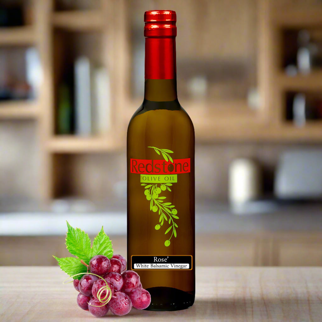 Close-up of Rose White Balsamic Vinegar bottle in kitchen with red grapes in the background