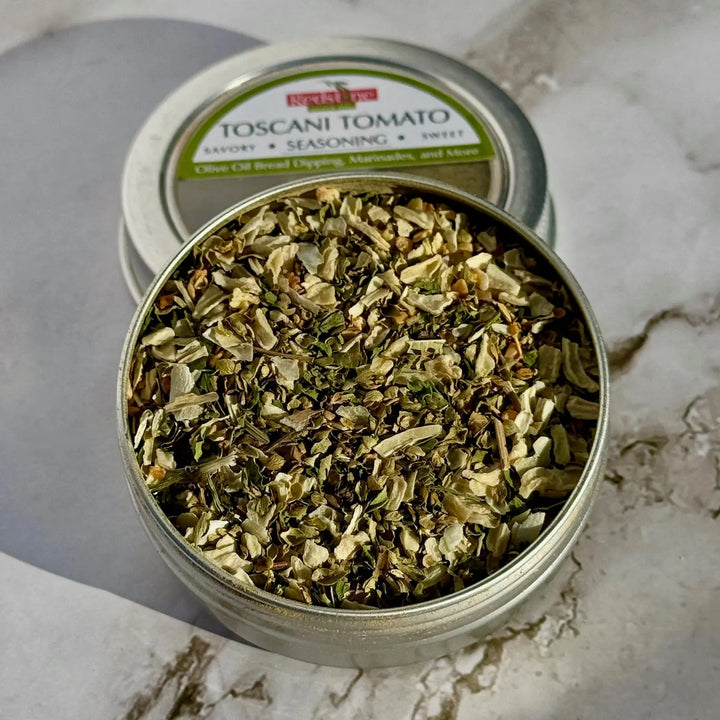 Open tin of Toscani tomato savory seasoning blend on marble surface