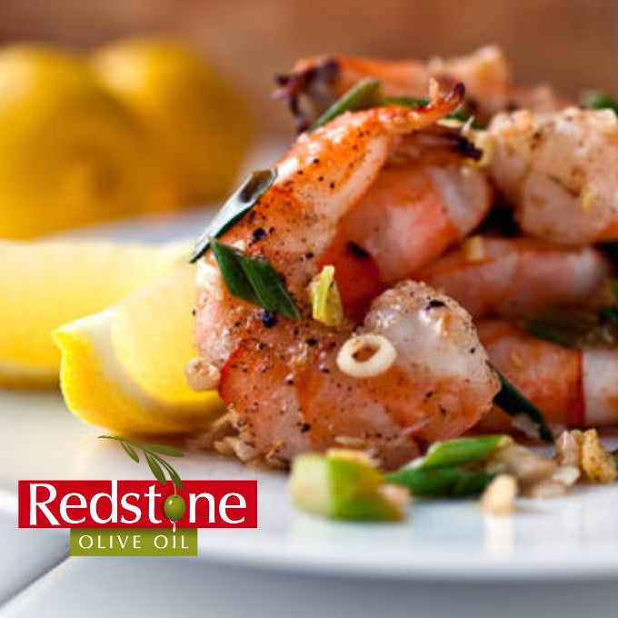 Shrimp dish with lemon wedges on a plate, featuring Redstone Olive Oil branding.