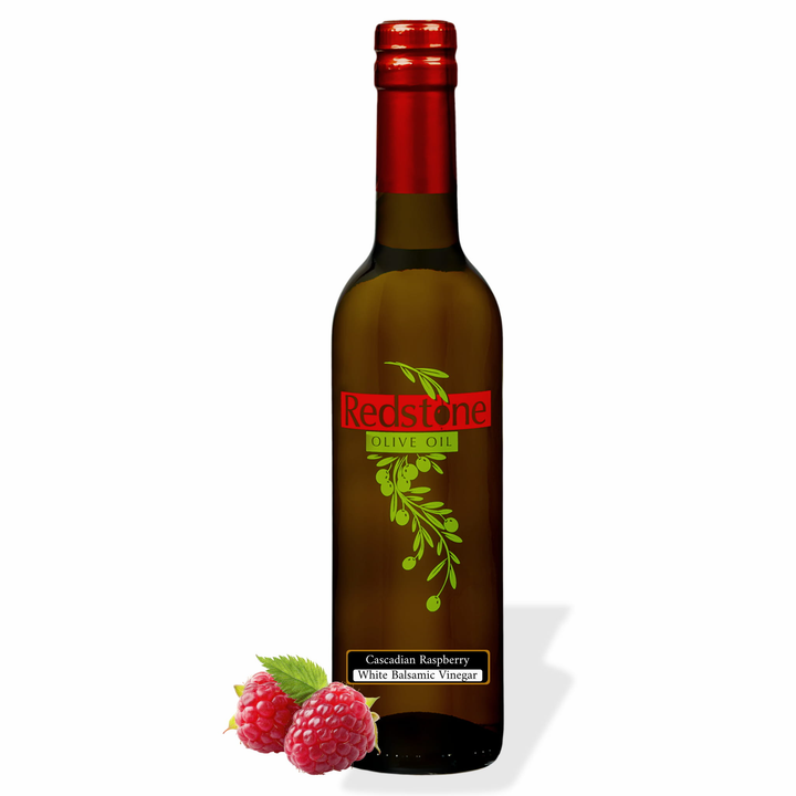 Bottle of Redstone Cascadian Wild Raspberry White Balsamic Vinegar with two fresh raspberries and a leaf