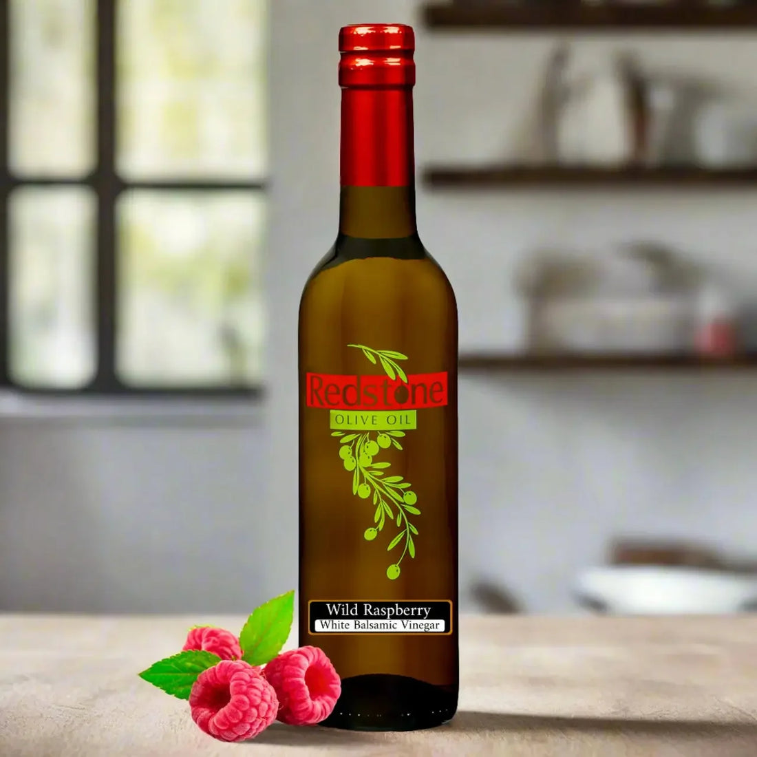 Bottle of Redstone Cascadian Wild Raspberry White Balsamic Vinegar with raspberries on a sunlit kitchen counter