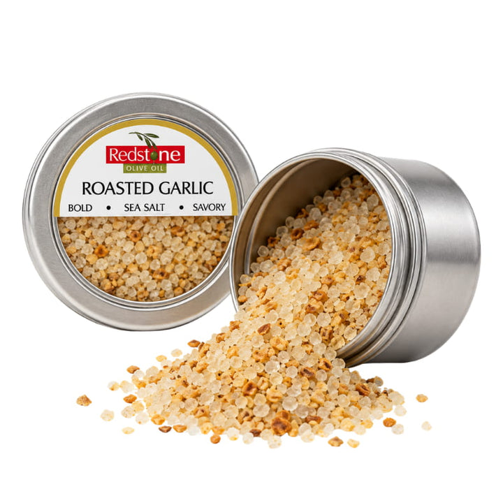 Redstone Roasted Garlic Sea Salt open tin spilling golden roasted garlic sea salt crystals — all-natural gourmet finishing salt
